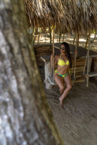 Amerika, Karibik, Große Antillen, Dominikanische Republik, Cabarete, Frau sitzt auf einer Schaukel an der Beachbar des Natura Cabana Boutique Hotel & Spa Amerika, Karibik, Große Antillen, Dominikanische Republik, Cabarete, Frau sitzt auf einer Schaukel an der Beachbar des Natura Cabana Boutique Hotel & Spa